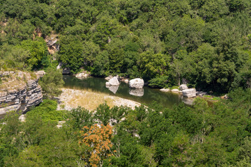 View of the river Ardeche, framed by rock faces and a lot of vegetation at "Cirque des Gens" in the department Ardeche in the south of France