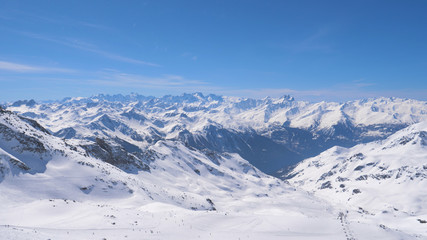 Fototapeta na wymiar A Breathtaking Panorama of the Snowy Mountains and Skiers