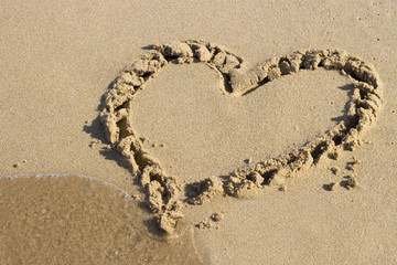 heart drawn on sand and sea, view from above