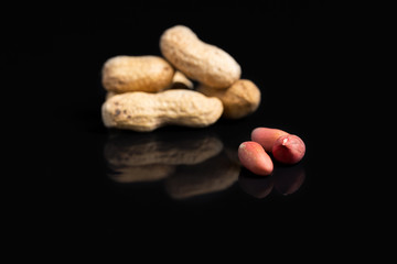 Peanut in shell on a black background with reflection.