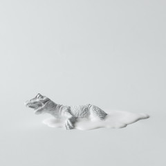 White painted dinosaur on white flat background. Minimal art concept.