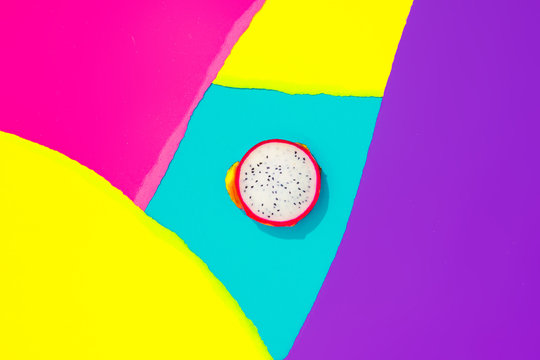 Creative tropical layout with dragonfruit and colorful vivid papers. Abstract colors art background. Minimal summer concept. Flat lay.