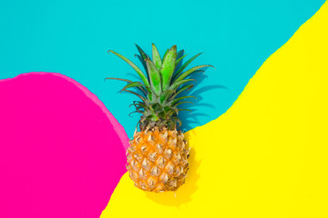 Creative tropical layout with pineapple and colorful vivid papers. Abstract colors art background. Minimal summer concept. Flat lay.