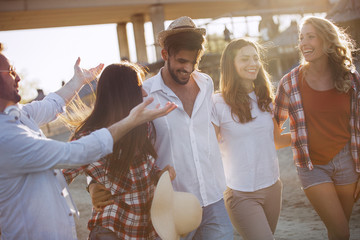 Group of happy young friends having great time on beach