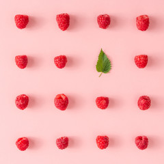 Creative neatly arranged food layout with raspberries and green leaf on pink background. Minimal healthy food concept. Flat lay.