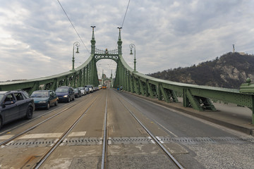 View of a chain bridge across the Danube against a cloudy sky background