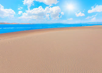 Fototapeta na wymiar Empty beach with sand dunes waves and sea