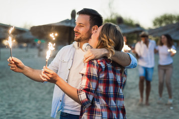 Picture of happy couple holding burning sparkle