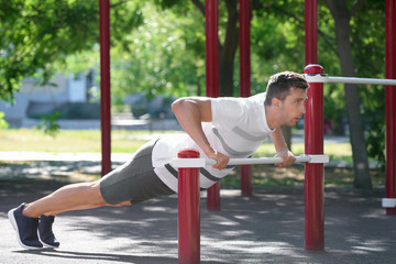 Fototapeta premium Sporty young man training on athletic field outdoors