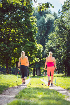 Mother and daughter doing Nordic Walking as means to gain better fitness
