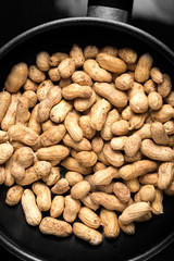 Fried peanuts in a frying pan, top view.