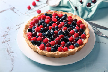 Plate with delicious berry pie on table
