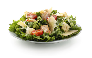 Plate with tasty Caesar salad on white background