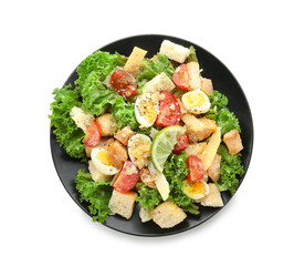 Plate with tasty Caesar salad on white background