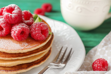 Tasty homemade pancakes with raspberries on plate, closeup