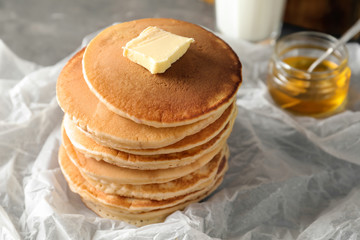 Tasty pancakes with butter on table