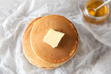 Tasty pancakes with butter on table