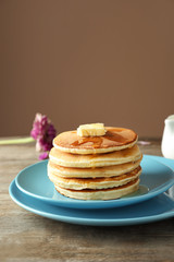 Plate with tasty pancakes on wooden table