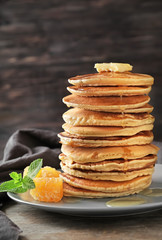 Plate with tasty homemade pancakes and honey comb on table