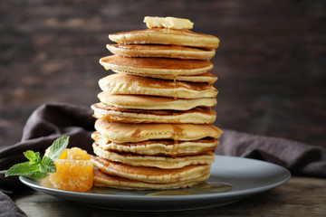 Plate with tasty homemade pancakes and honey comb on table