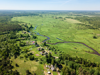 Beautiful aerial view of meandering river with bright green fiel