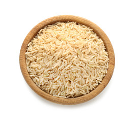 Wooden bowl with raw brown rice on white background