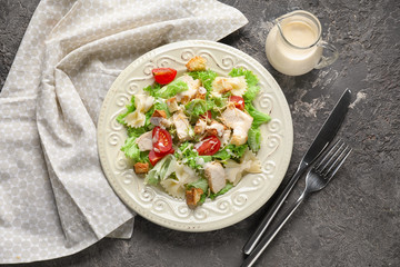 Tasty Caesar salad with pasta on table