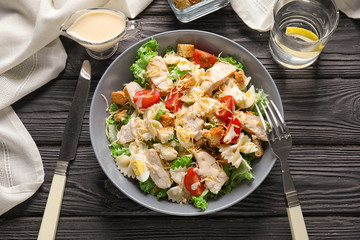 Tasty Caesar salad with pasta on table