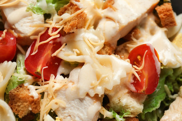 Tasty Caesar salad with pasta, closeup