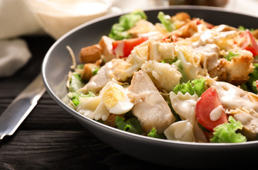 Tasty Caesar salad with pasta on plate, closeup