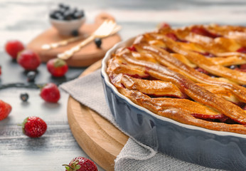 Tasty pie with berries on wooden board, closeup