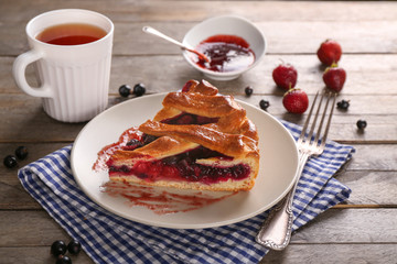 Piece of tasty pie with berries on plate