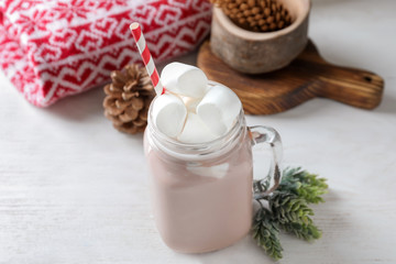 Mason jar of hot cocoa with marshmallows on white table