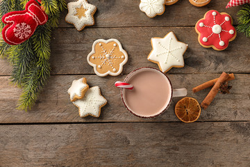 Cup of hot cocoa with Christmas cookies on wooden table