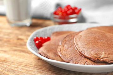 Plate with delicious chocolate pancakes on table, closeup