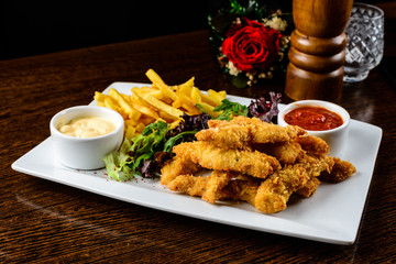 Juicy crispy chicken wings and golden French fries served with l