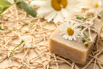 Obraz na płótnie Canvas Bar of natural soap with chamomile flowers on table