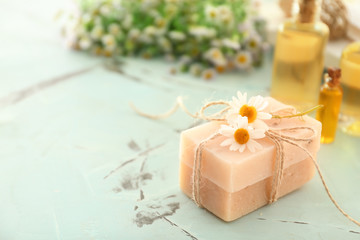 Obraz na płótnie Canvas Bars of natural soap with chamomile flowers on table
