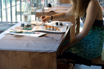 sitting woman eating sushi meal