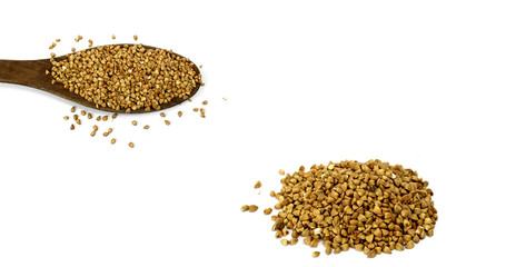 russischer Buchweizen isoliert auf Holzlöffel und häufchen weißer Hintergrund