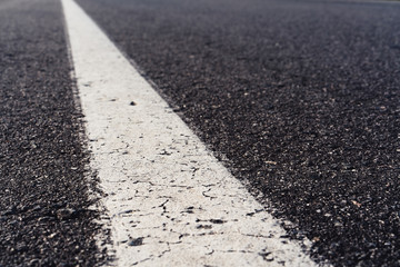 Black asphalt road and white dividing lines