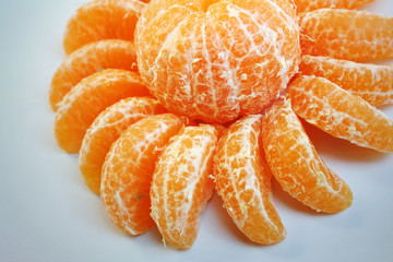 Slices of mandarin orange on white plate fruit background