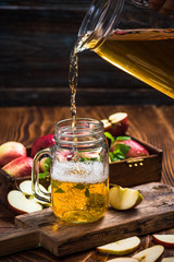Pouring fresh and healthy apple juice into glass