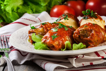 Stuffed cabbage with meat and rice served with boiled potatoes and tomato sauce