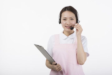 ヘッドセットをつけて微笑む白衣を着た女性
