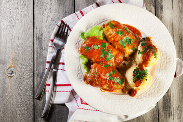 Stuffed cabbage with meat and rice served with boiled potatoes and tomato sauce
