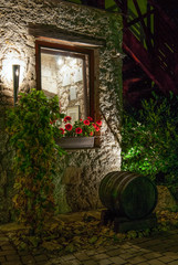 Naklejka premium An old wooden barrel under the window, evening