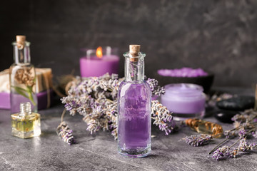 Obraz na płótnie Canvas Bottle of essential oil with lavender on table