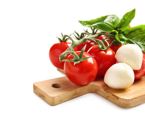 Wooden board with fresh ripe cherry tomatoes and mozzarella cheese on white background