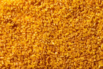 Macro image of bulgur grains as natural vegan food background. Top view